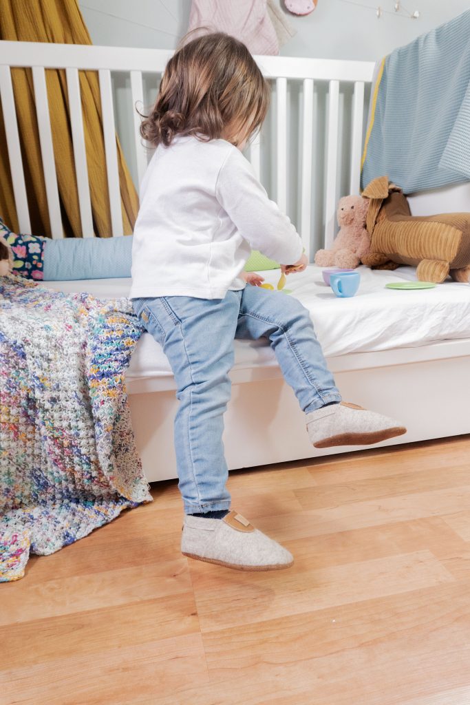 Kind trägt Wollhausschuhe in Braun